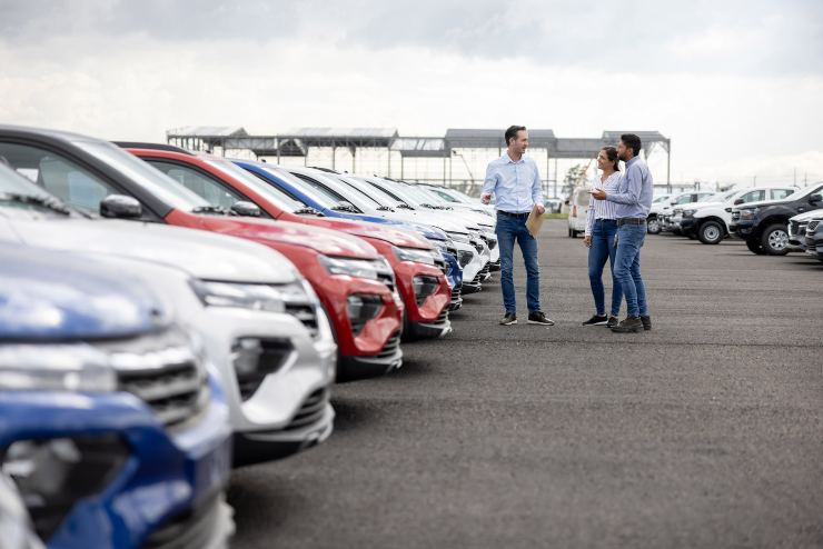 Coppia in una concessionaria auto che parla con il commerciante
