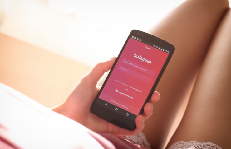 donna con in mano il cellulare su Instagram