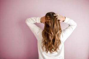 Donna di spalle che si tocca i capelli