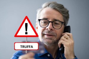 Uomo che parla al telefono e segnale di pericolo