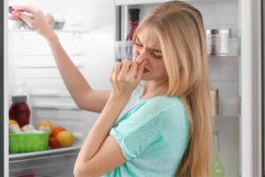 donna che si tappa il naso per la puzza in frigo