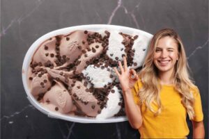 Gelato nella vaschetta, ragazza in primo piano fa occhiolino e ok con le dita
