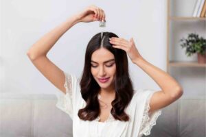 Donna applica olio nei capelli