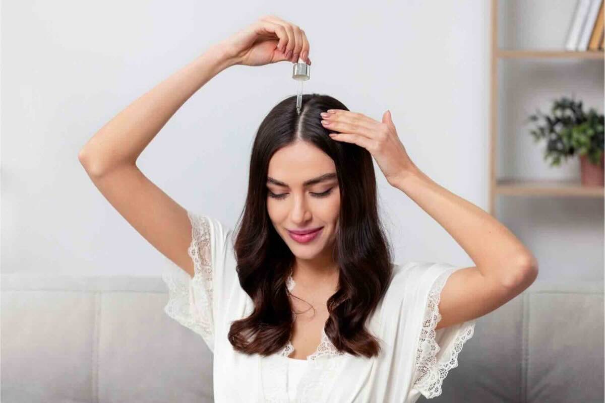 Donna applica olio nei capelli