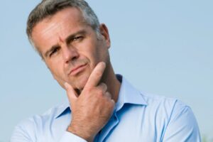 uomo perplesso che si tocca il mento