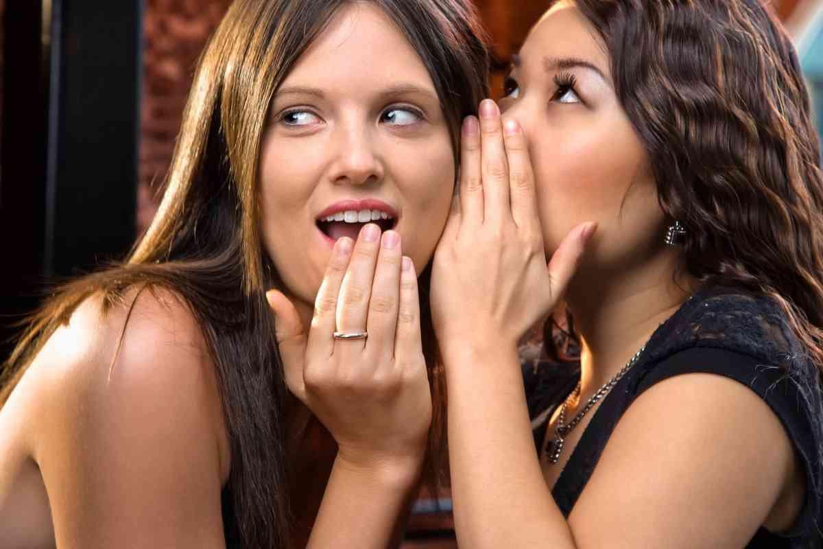 Una donna che parla nell'orecchio di un'altra