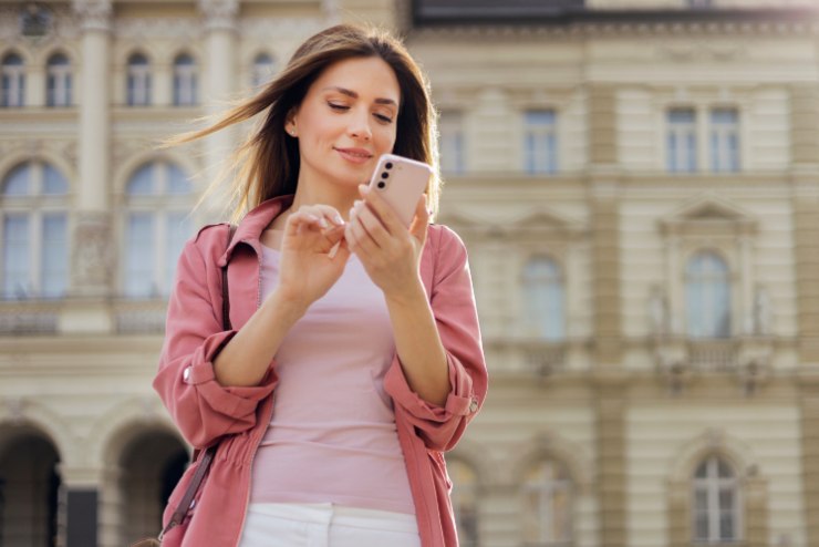 donna per strada con il cellulare in mano